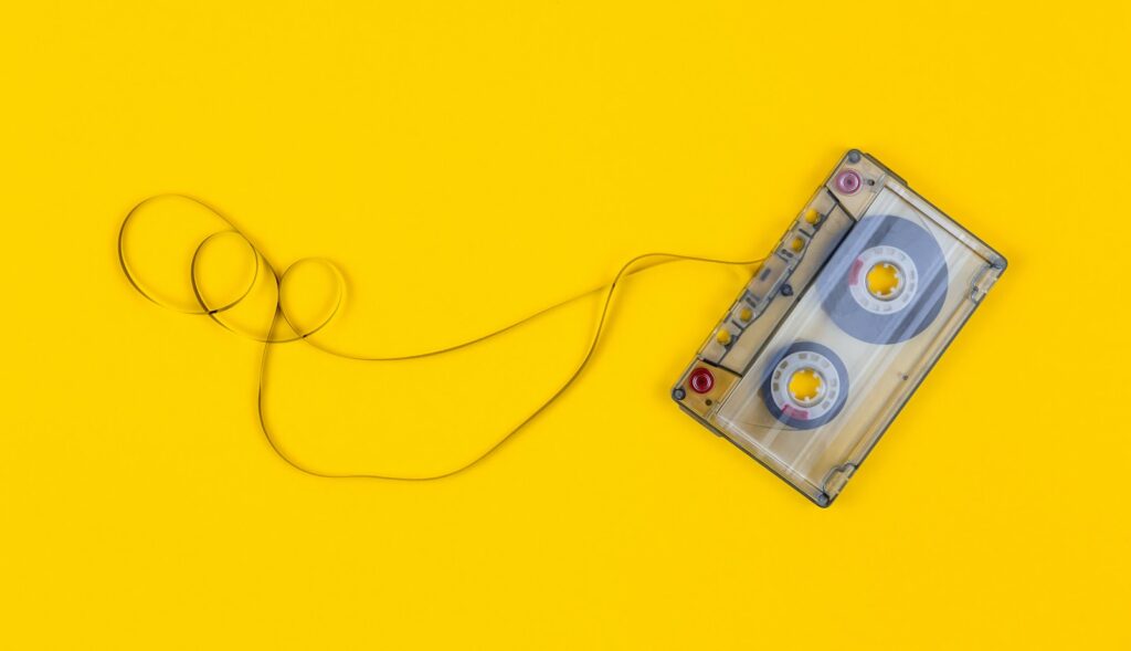 gray cassette tape on yellow surface showcasing music band isntruments